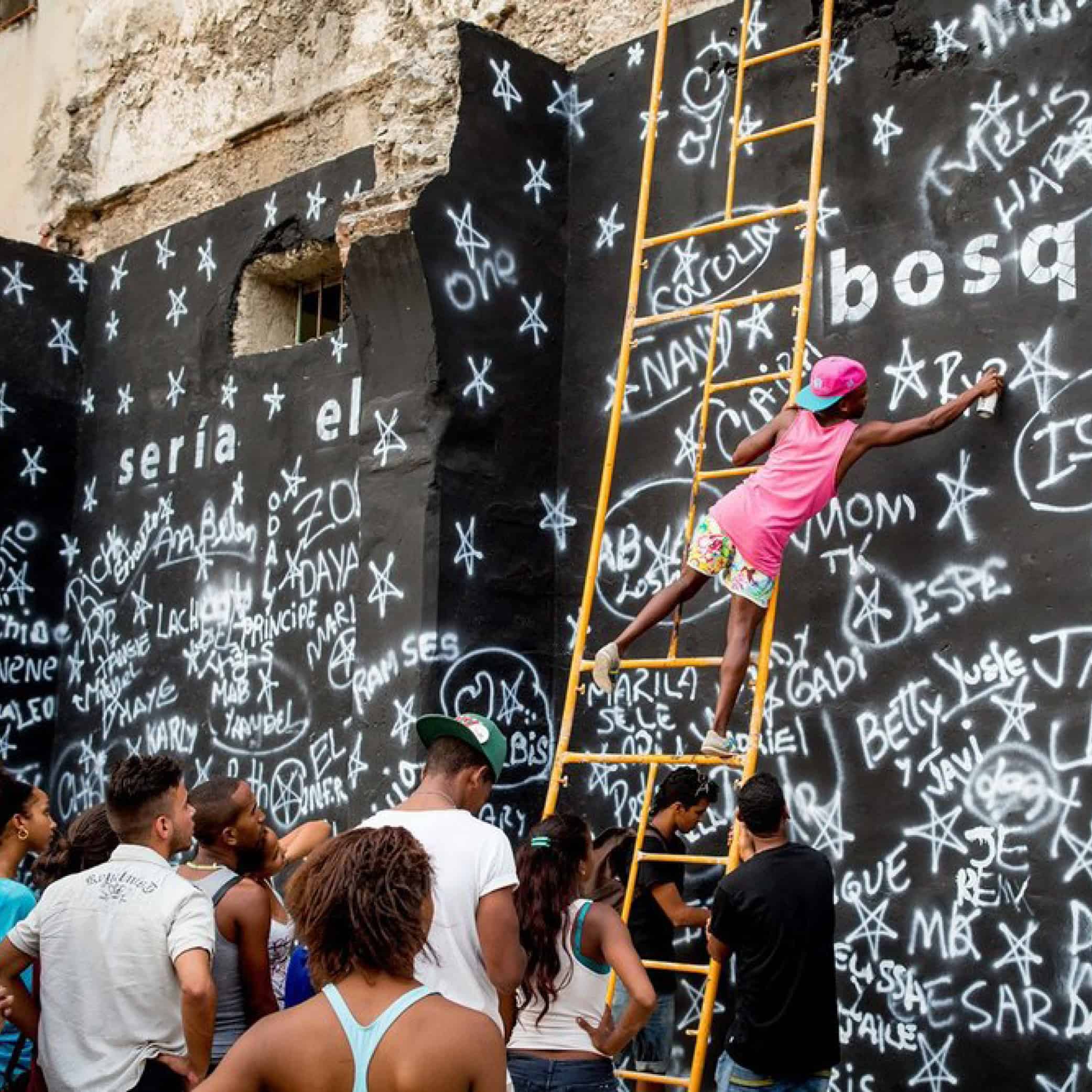 A group of people spray painting a wall