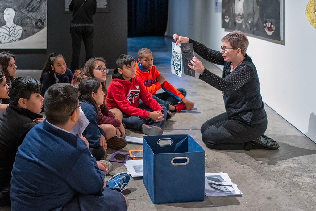 A women teaching young students about art