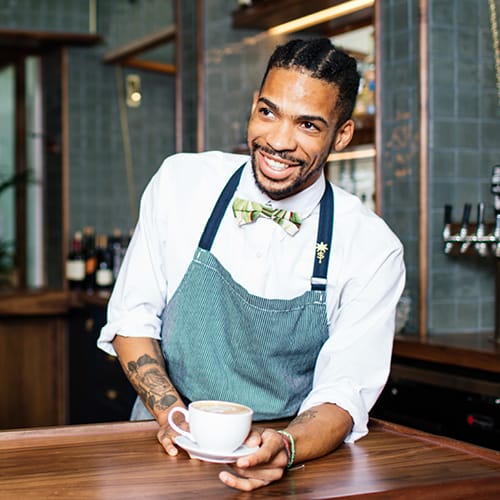 A barista holding a latte